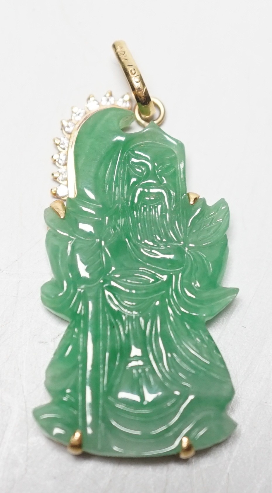 A modern 18k and diamond chip mounted jadeite pendant, carved as an immortal, 40mm, gross weight 9.1 grams.